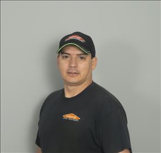 Male employee with black hat in front of tan background
